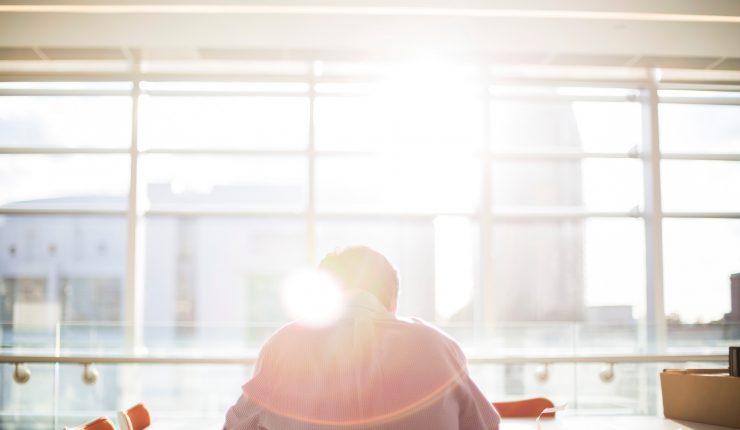 Man working in an office with the sun over his shoulder