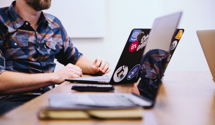 Man working on a laptop with stickers